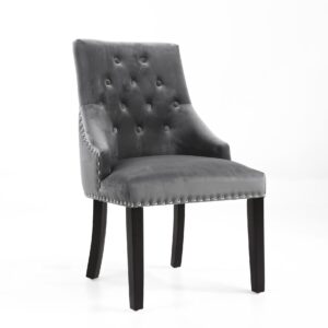 Gray upholstered dining chair with tufted backrest, silver nailhead trim, and dark wooden legs. Elegant and modern design against a white background.