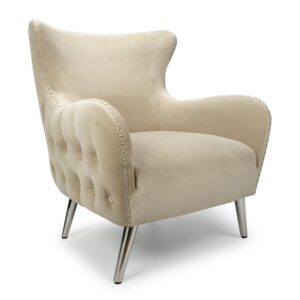 Elegant beige armchair with plush velvet upholstery, featuring button-tufted back, studded edges, and shiny silver legs. Conveys luxury and comfort.