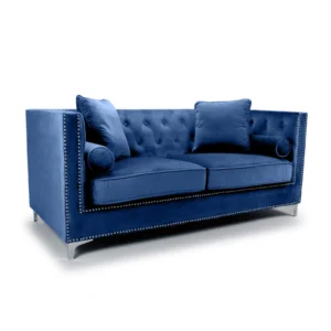Luxurious blue velvet sofa with tufted backrest and silver stud detailing. Includes two large square pillows and two cylindrical bolster cushions.